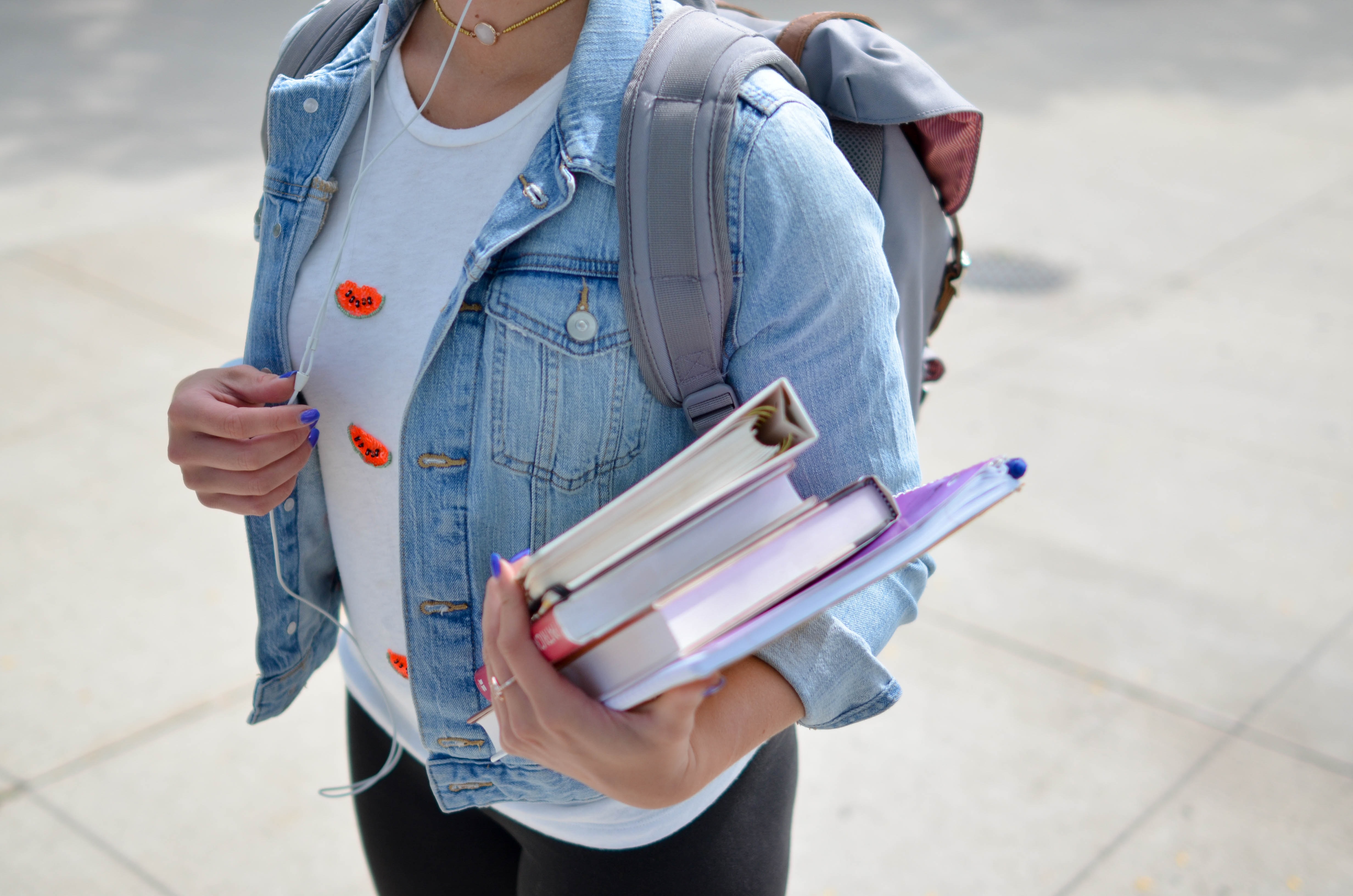 Bilde av en student med bøker i hendene.